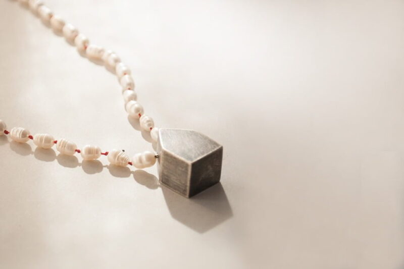 collar con perlas de rio y casita de plata negra