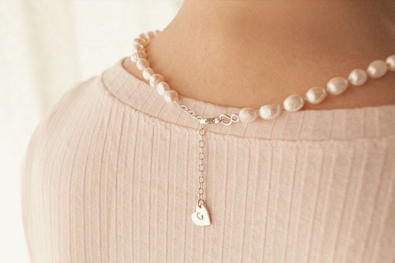 Collar Emily con perlas de río enhebradas con la técnica de enfilado de perlas. Detalle del cierre con corazón de plata 925.Bruselas Joyería Contemporánea